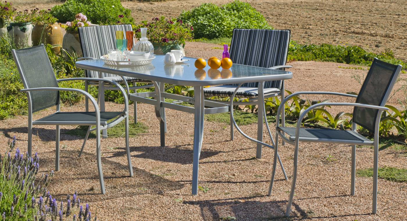 Conjunto de acero color plata: mesa de 150x90 cm. Con tablero de cristal templado + 4 sillones de acero y textilen
