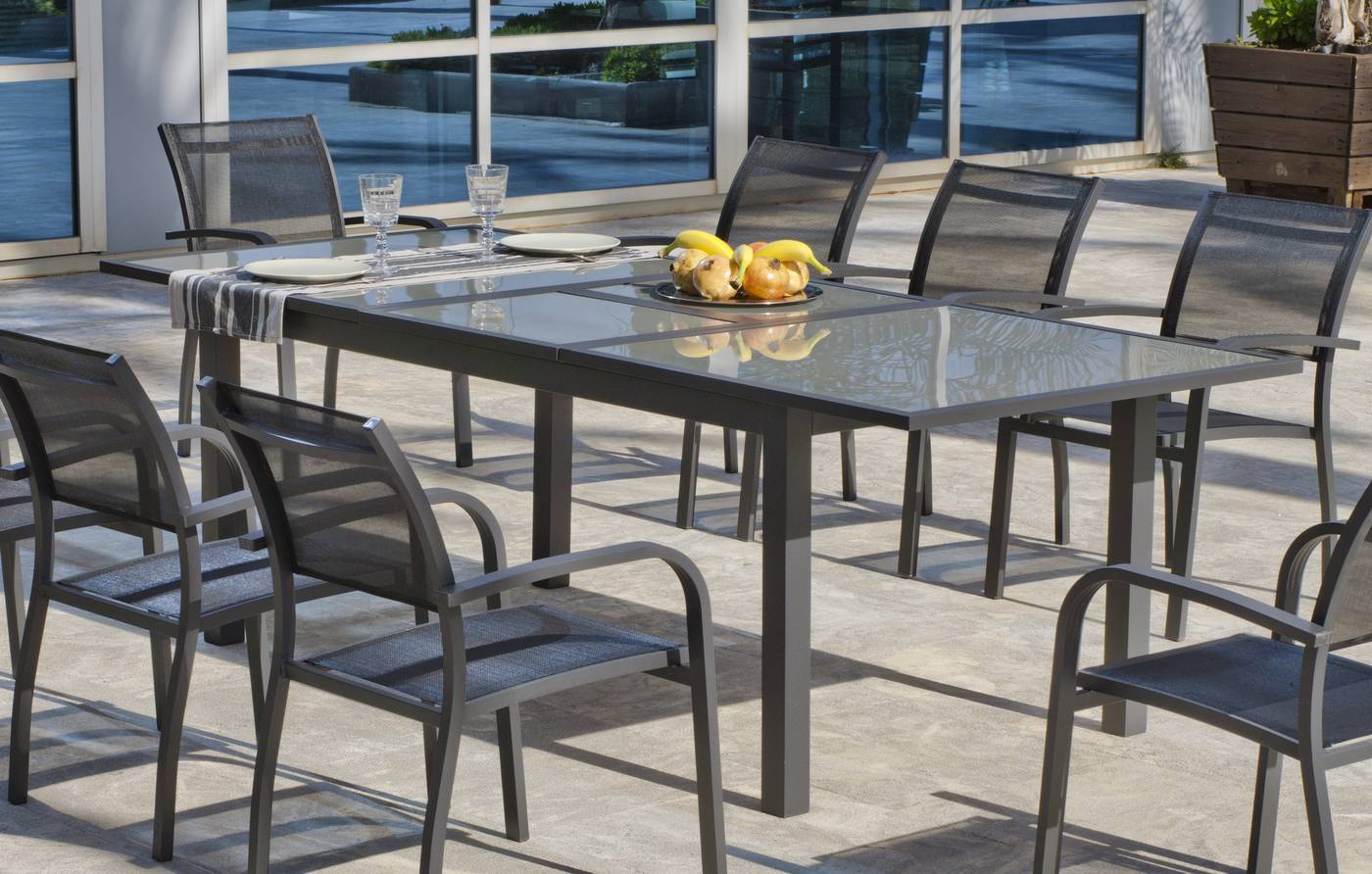 Mesa extensible 180-240 cm, de aluminio color antracita con tablero de cristal templado. Válida para 10 sillones.