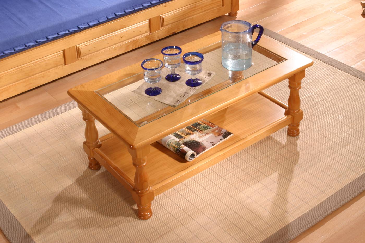 Mesa de centro rectangular de madera de pino, con revistero y tapa de cristal. Disponible en varios colores.