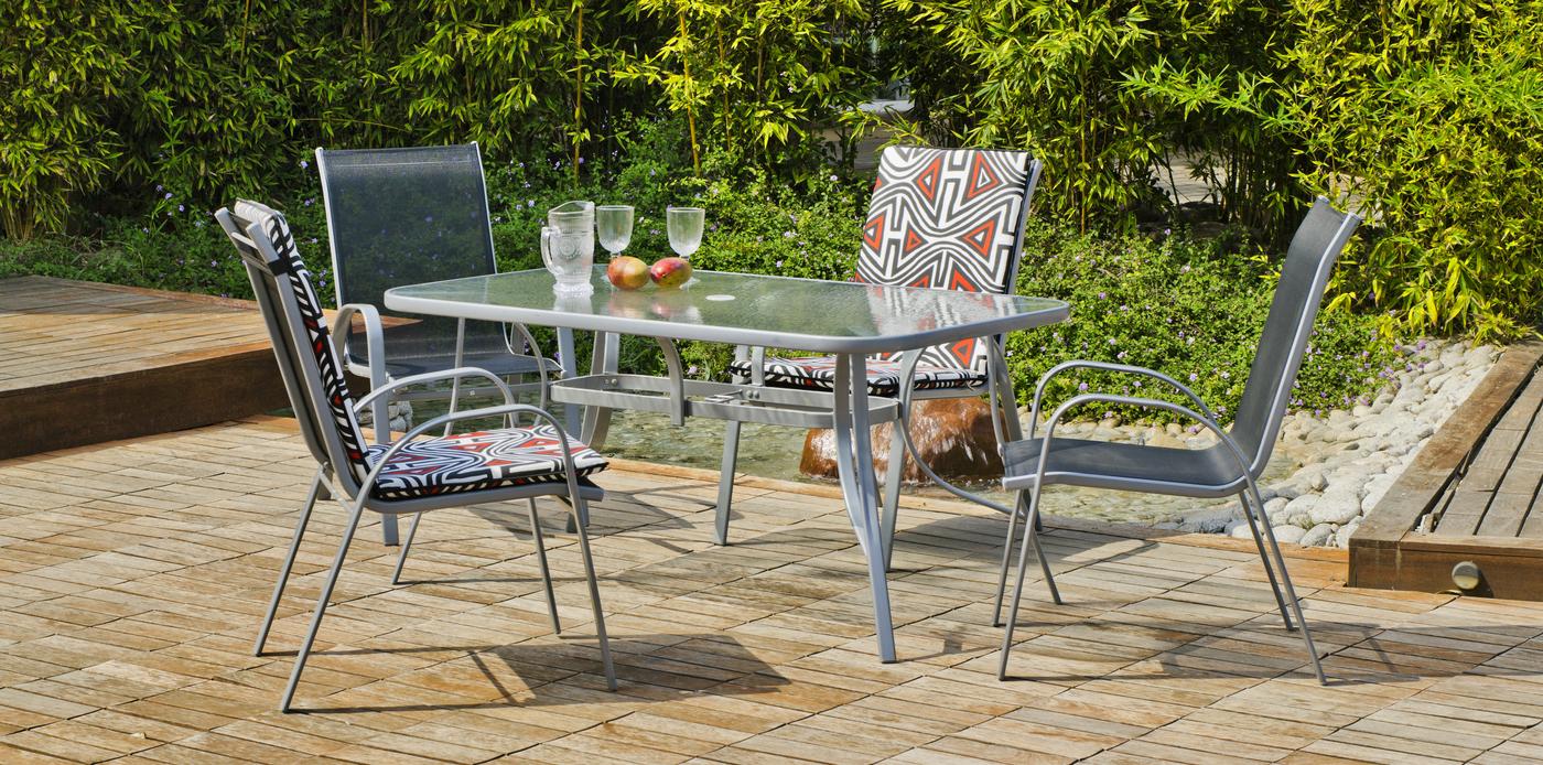Conjunto de acero color plata: mesa de 150x90 cm. Con tablero de cristal templado + 4 sillones apilables de acero y textilen